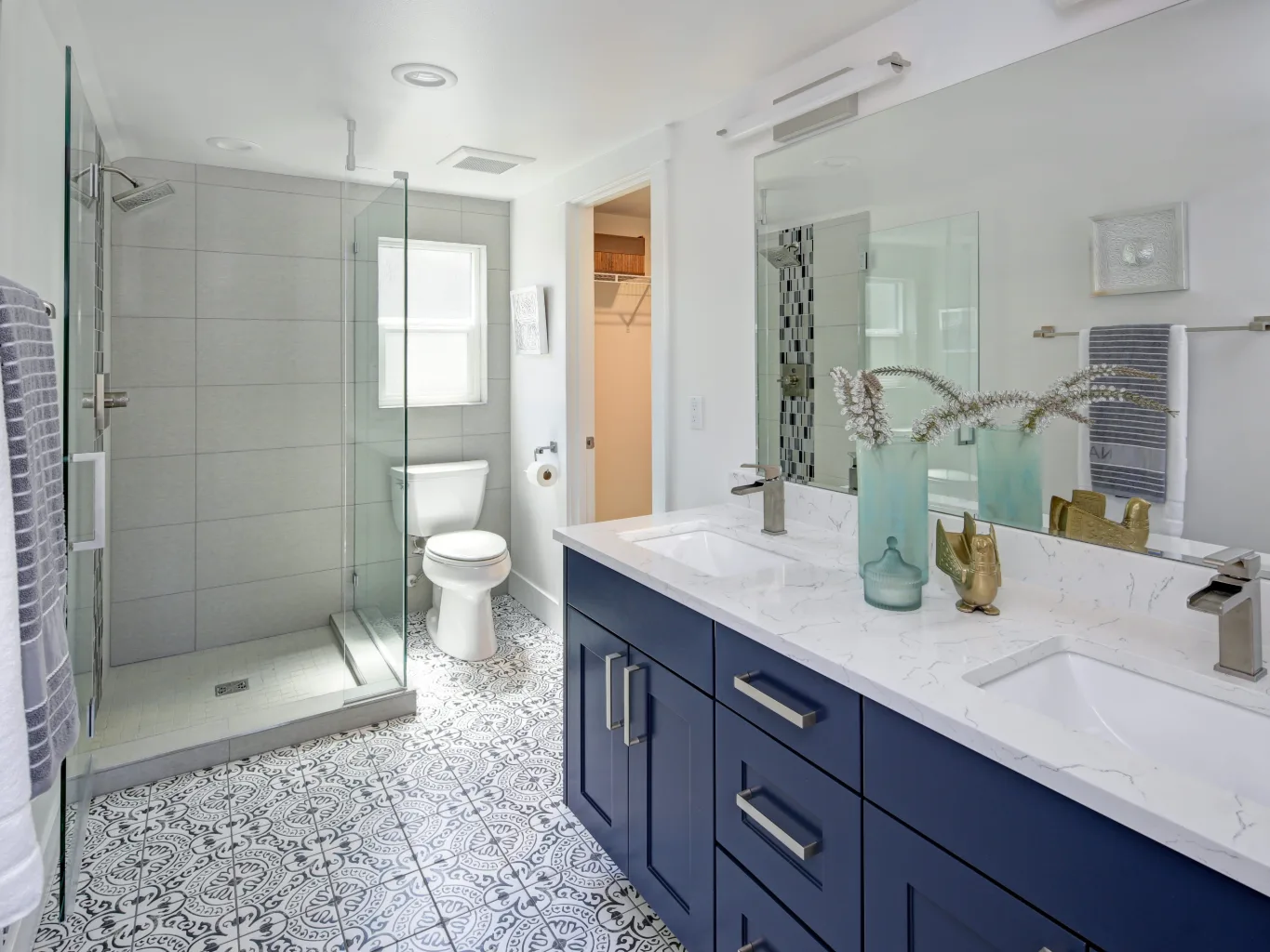 A handyman working on a residential bathroom & kitchen remodeling job — mid-task, hands, tools and the work itself in sharp focus, the rest of the space softly out of focus